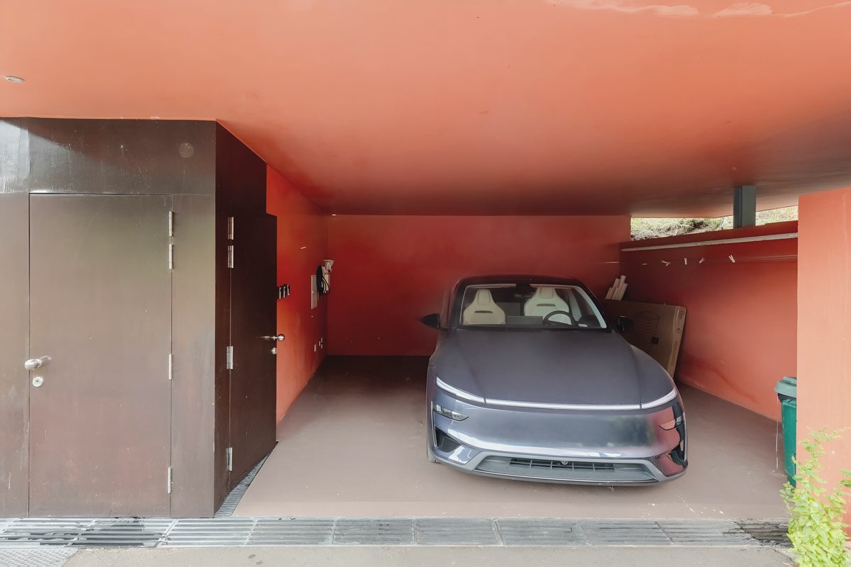 The house Tesla in the orange carport at Casa Keam, plugged in to charge