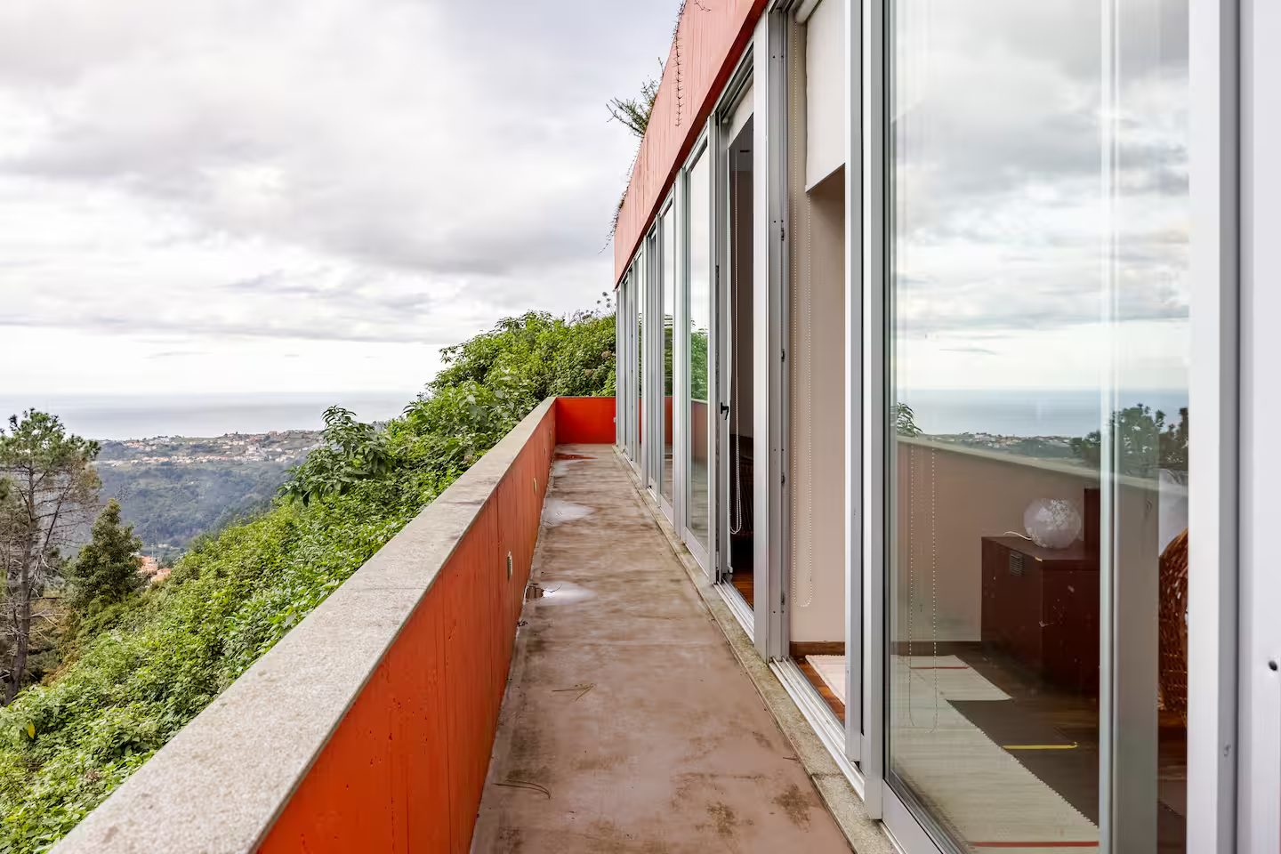 Terrazza della camera ospiti, muro arancione e vista sul versante fino all’Atlantico