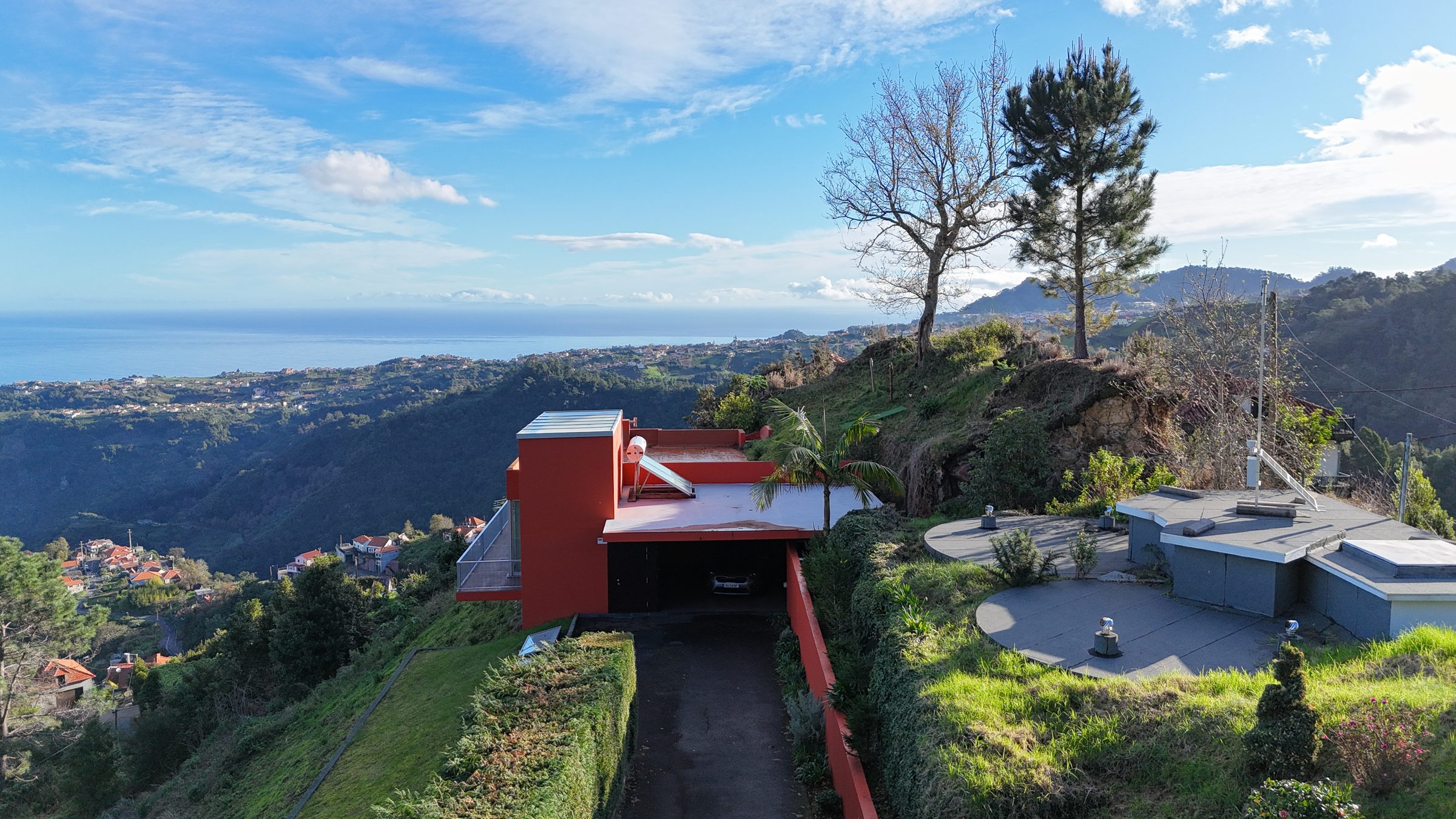 Driveway and orange villa with the village and ocean beyond