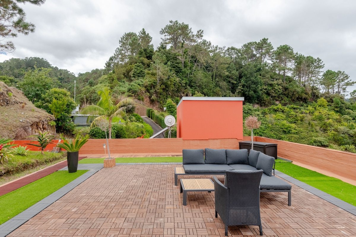 High-angle rooftop terrace with outdoor seating and panoramic ocean view