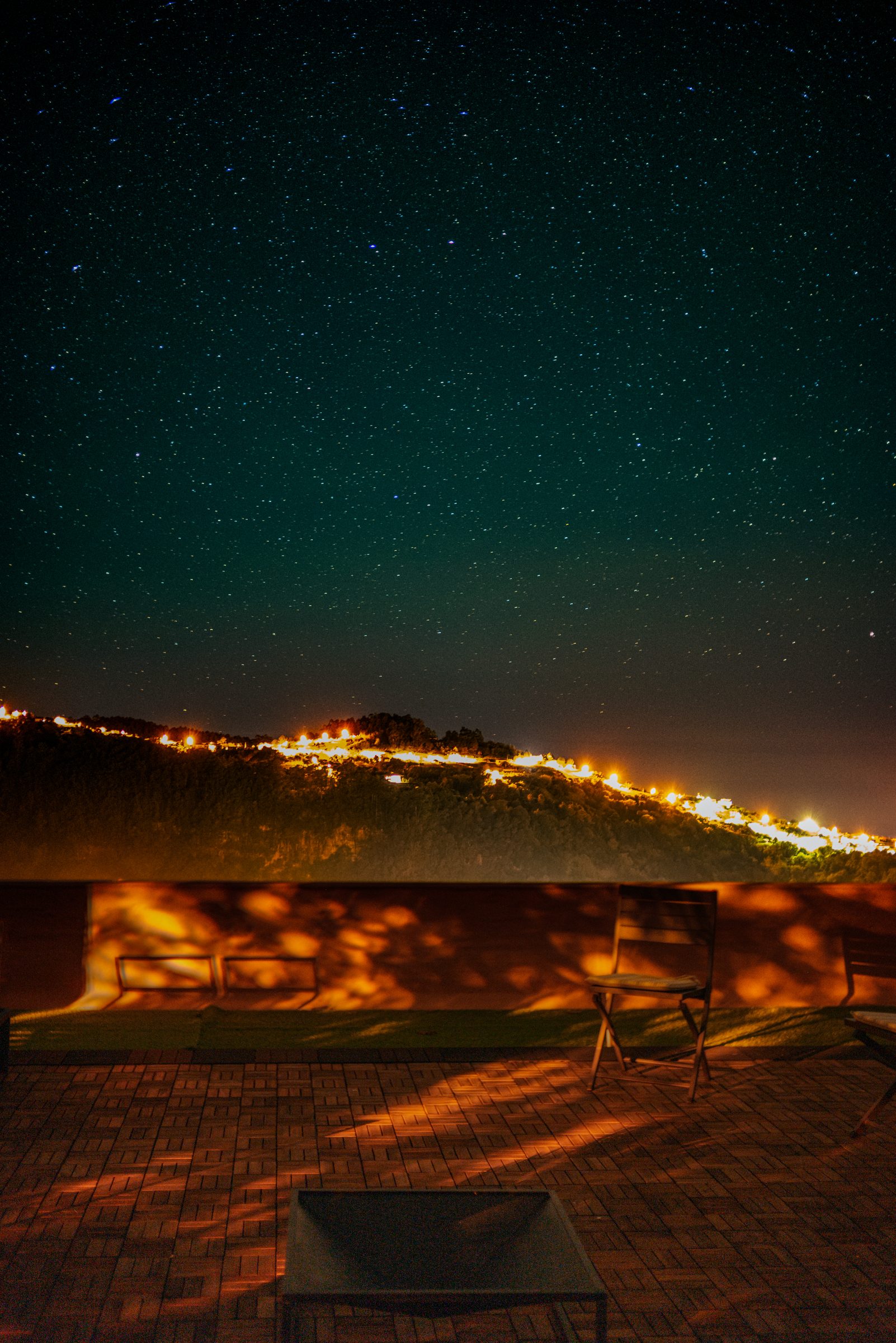 Starry night from the rooftop terrace, looking over hillside lights