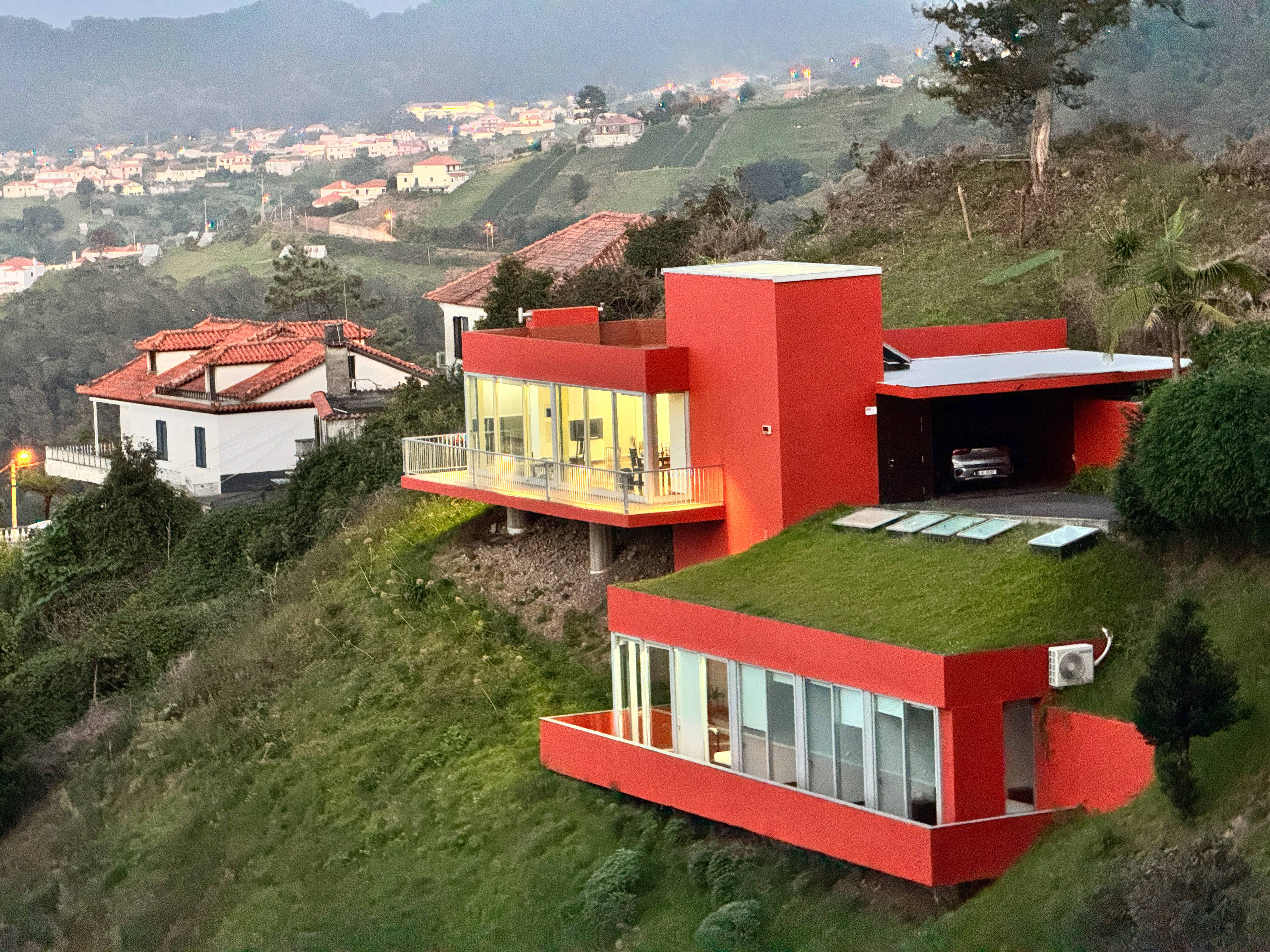 Casa Keam at dusk, lights on, above the Santana valley