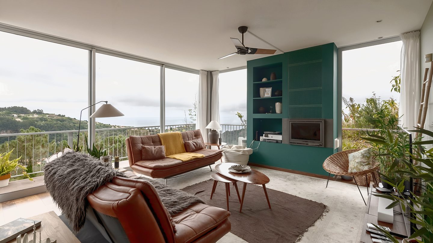 The living room, glass on two sides, looking out over the valley