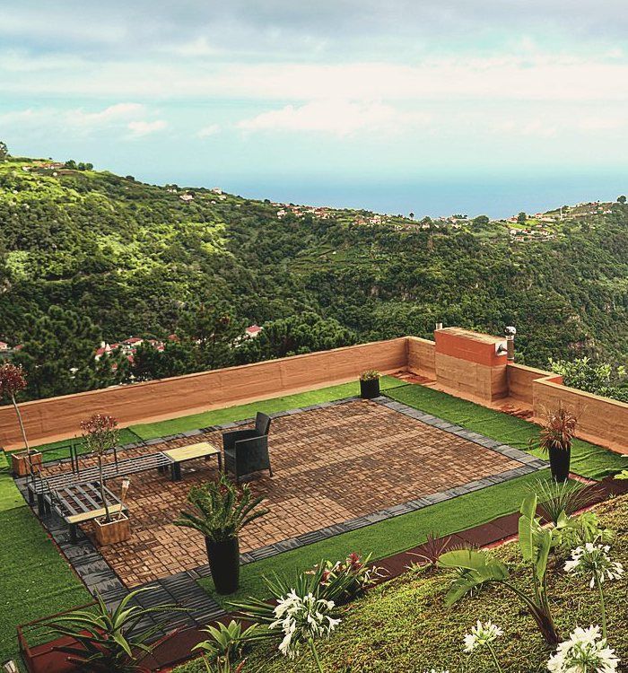 The walled rooftop terrace, with loungers and the valley running to the sea