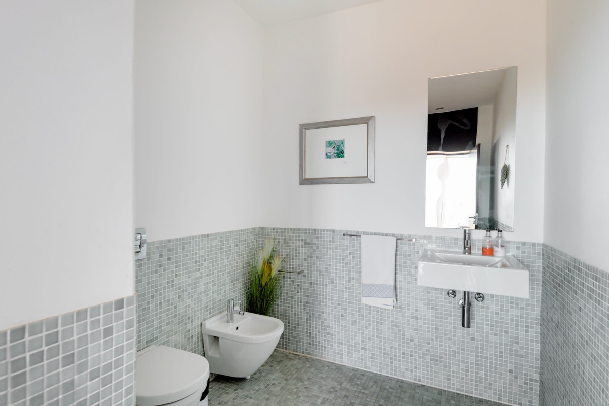 Upstairs bathroom with mosaic tile, bidet, and wall-mounted sink