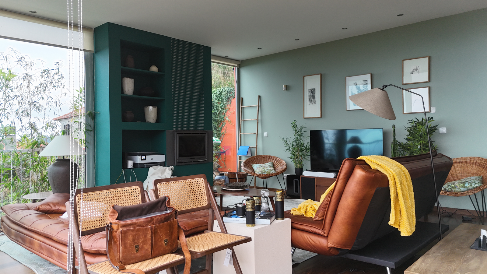 Living room with leather sofas, teal fireplace, and sage walls