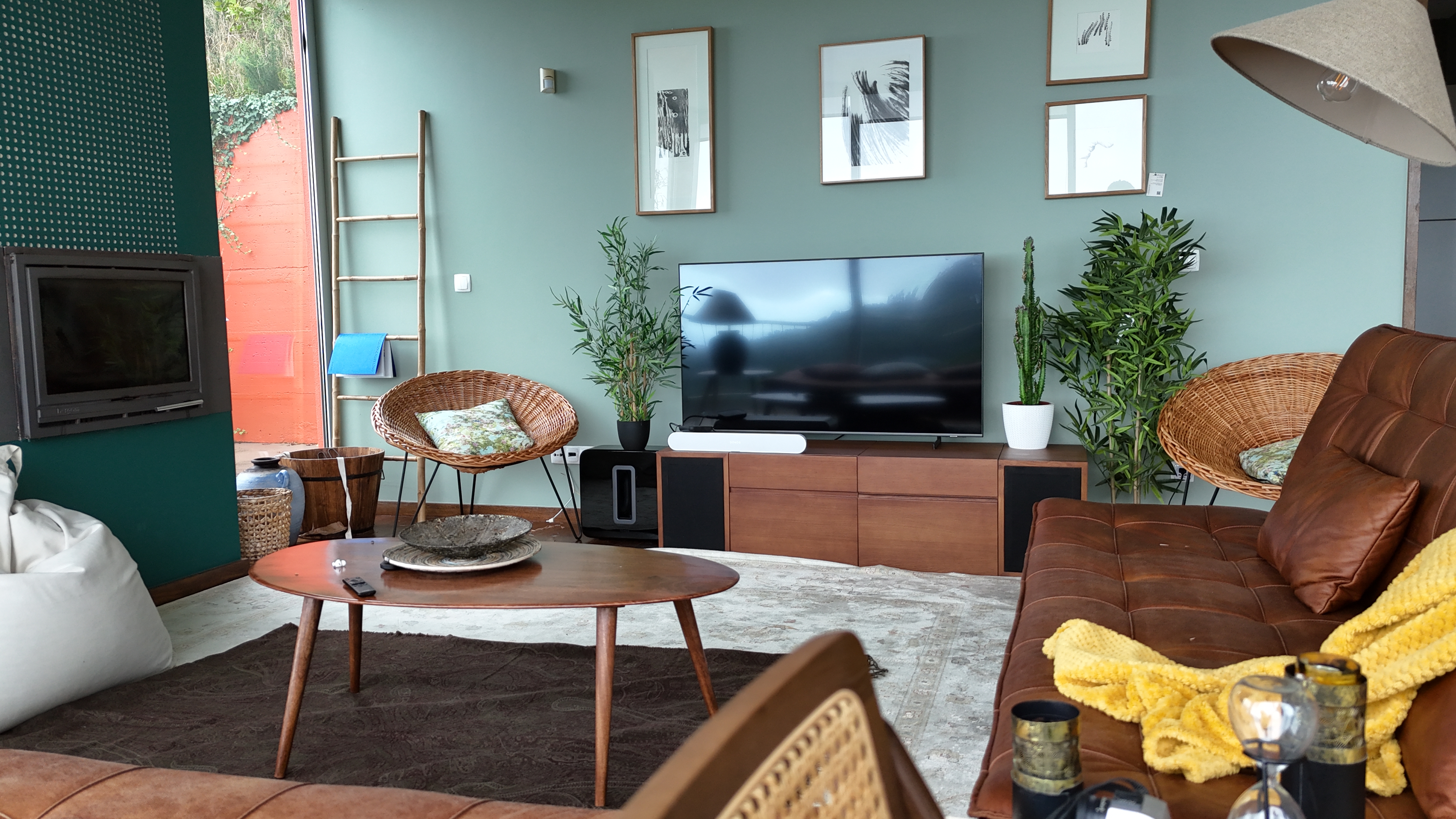 Living room with leather sofa, wicker chairs, and the orange terrace