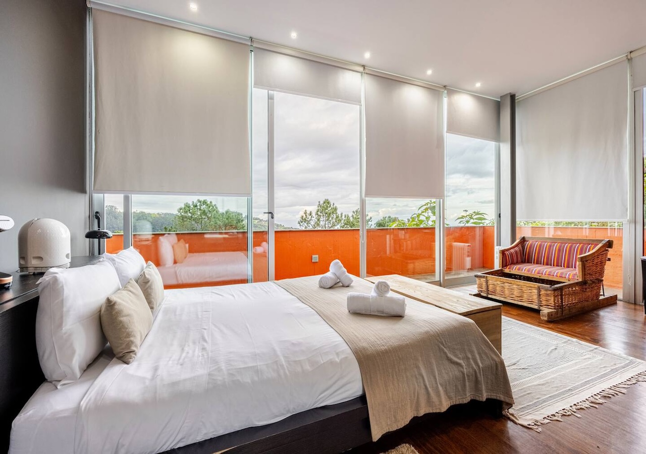 Master bedroom with wicker seating and floor-to-ceiling glass