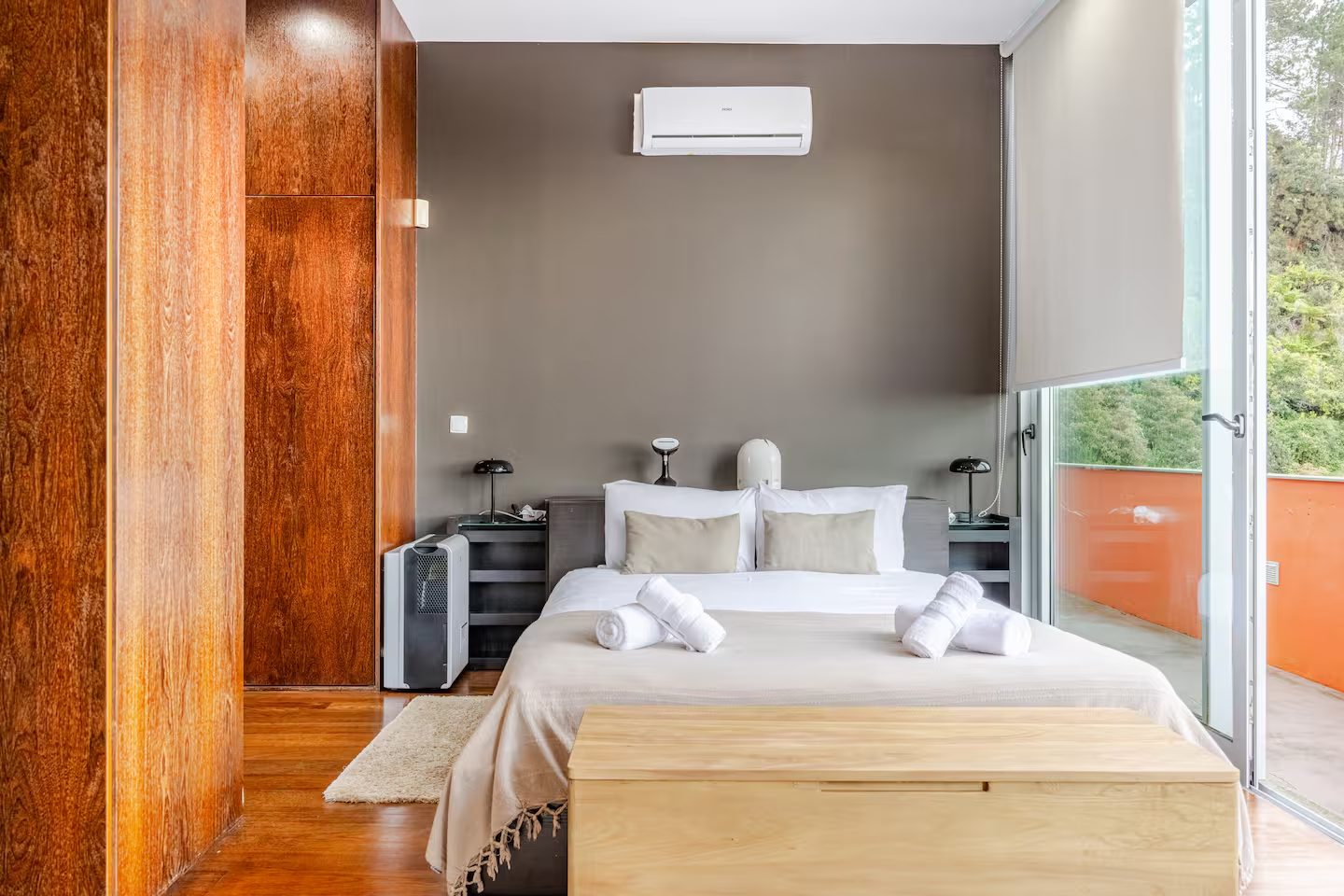 Master-Schlafzimmer mit taupefarbener Wand, weißer Bettwäsche und orangefarbener Terrasse