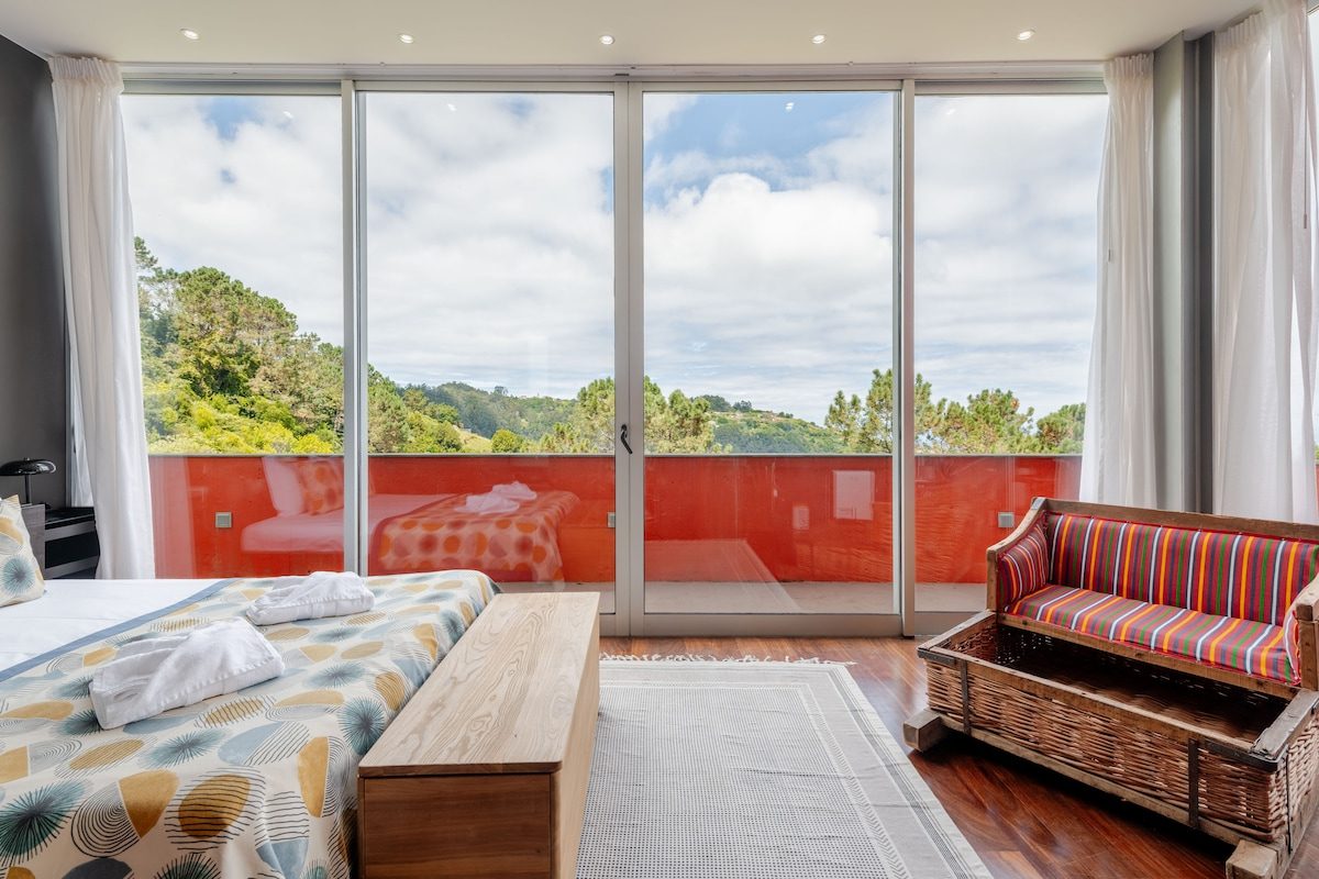 Master bedroom looking out to the orange balcony and green Santana hillside