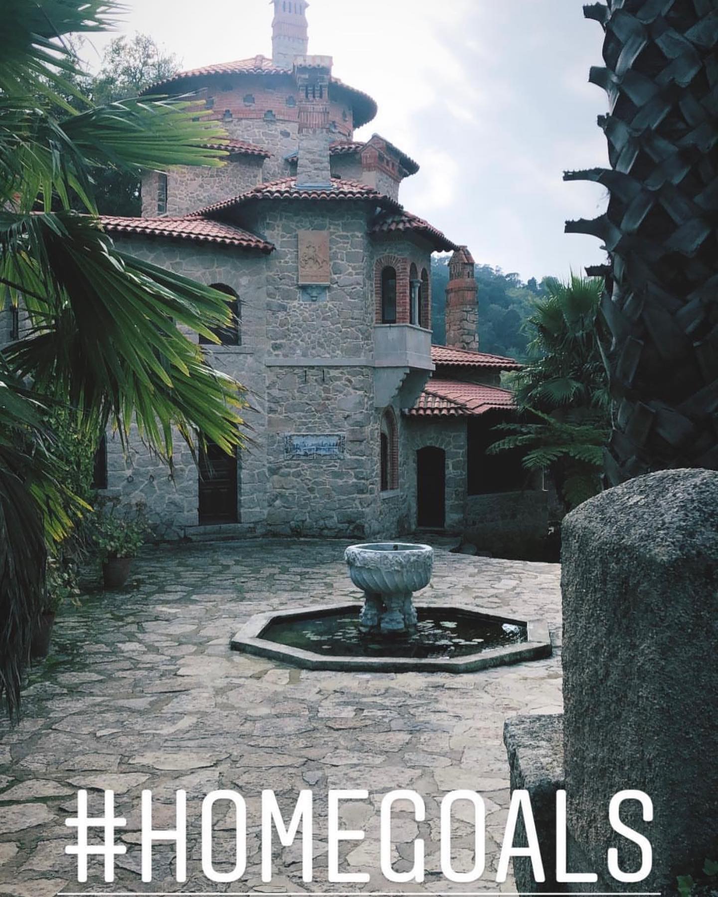 A stone villa courtyard in Sintra, with #HOMEGOALS written across the photo